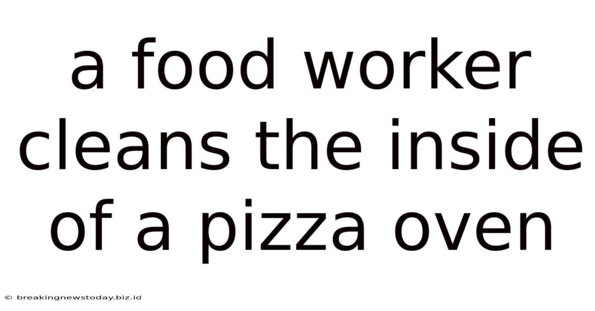 A Food Worker Cleans The Inside Of A Pizza Oven
